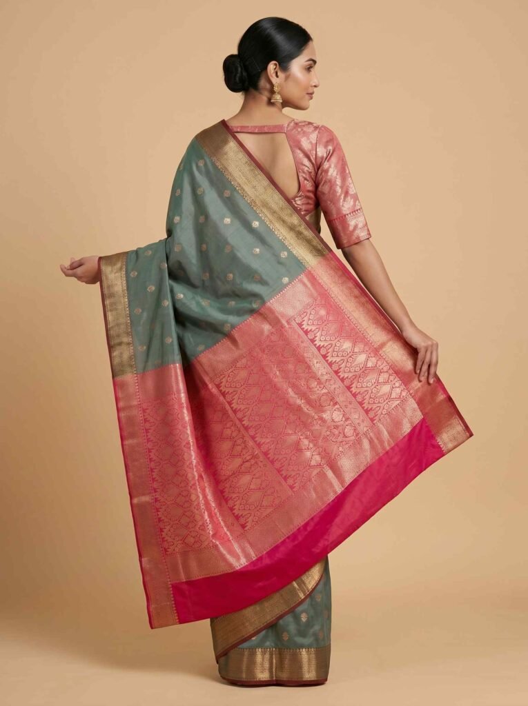 Premium semi silk Banarasi saree in sage green with contrasting pink pallu and border and delicate zari buti work