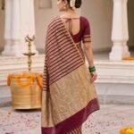 Premium Munga Silk Banarasi saree in maroon and gold with elegant zari stripe work and rich traditional border and pallu