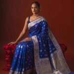 Premium handwoven Kataan Silk Banarasi saree in royal blue with colourful floral Meenakari work, intricate zari border and detailed pallu