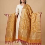Premium mustard Semi Kataan Silk Banarasi dupatta with golden zari floral jaal work, an ornate oval-motif border and pink tassels.