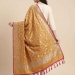 Premium mustard Semi Kataan Silk Banarasi dupatta featuring golden zari floral jaal work, an ornate zari border, pink edging and decorative tassels.