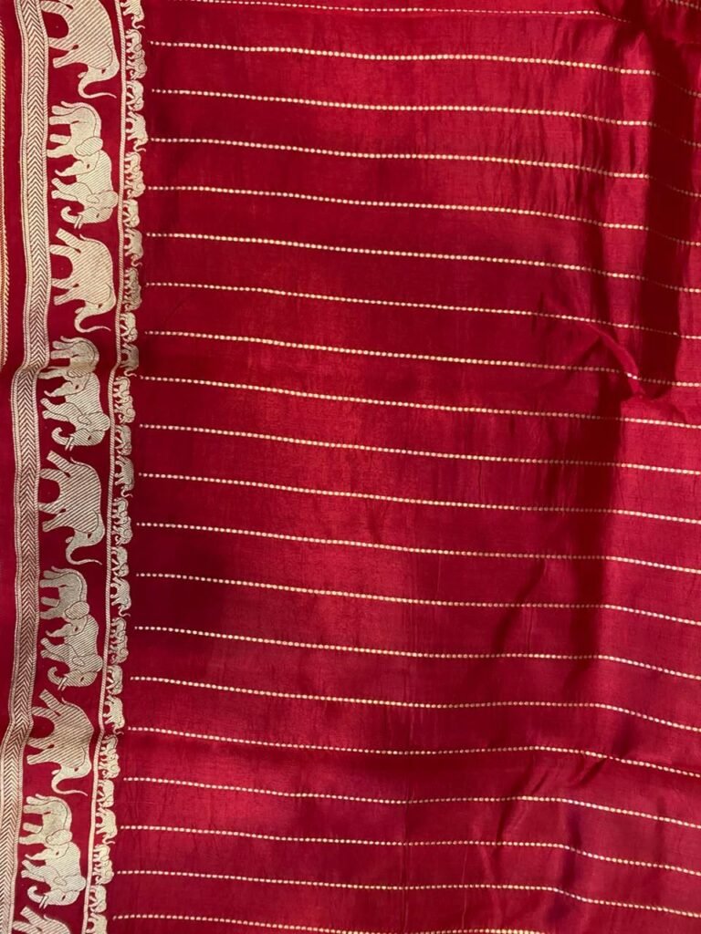 Premium green Banarasi saree with golden zari buti motifs, magenta border, traditional elephant designs and geometric pallu.