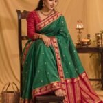 Premium green Banarasi saree with golden zari buti motifs, magenta border, traditional elephant designs and geometric pallu.